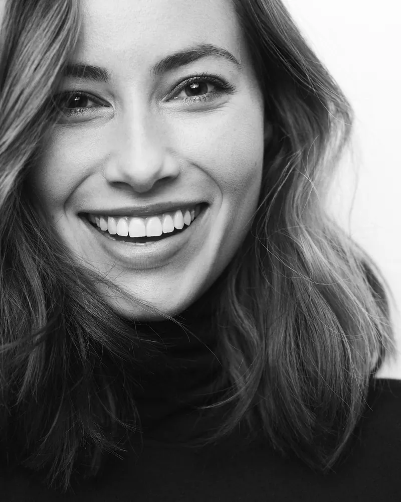 Smiling woman in a black turtleneck
